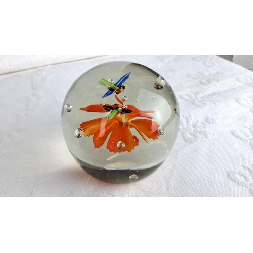 160 - Set of four handblown glass paperweights, each featuring a vibrant orange flower and delicate glass ... 