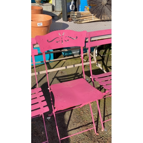 421 - Set of four pink metal folding garden chairs with decorative cut-out backs.