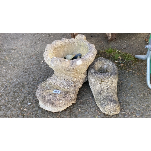 441 - Pair of stone garden ornaments shaped like boots with a rustic design.