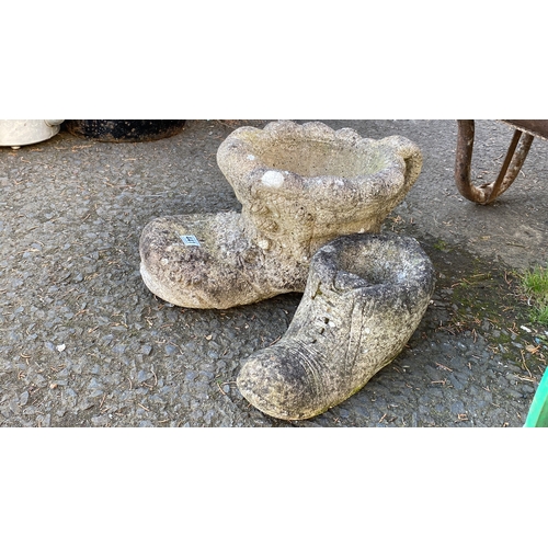 441 - Pair of stone garden ornaments shaped like boots with a rustic design.