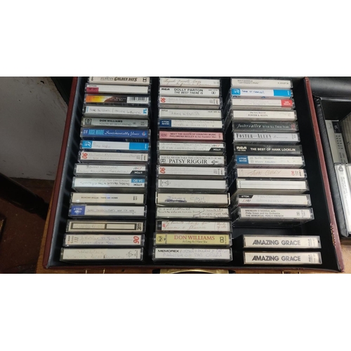 363 - Collection of vintage cassette tapes featuring various artists and genres, neatly organized in carry... 