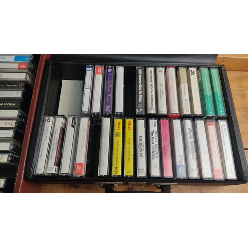 363 - Collection of vintage cassette tapes featuring various artists and genres, neatly organized in carry... 