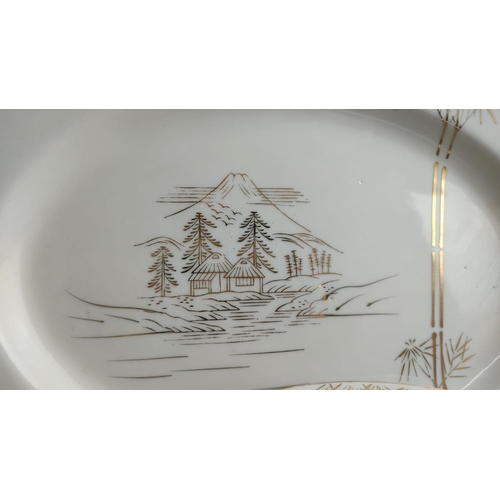 364 - Porcelain tea and dinner service set features a delicate gold landscape motif with houses and bamboo... 