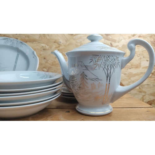 364 - Porcelain tea and dinner service set features a delicate gold landscape motif with houses and bamboo... 