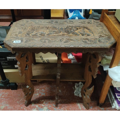 374 - Carved wooden table featuring animal motifs and detailed scrollwork, made from dark wood, from the e... 