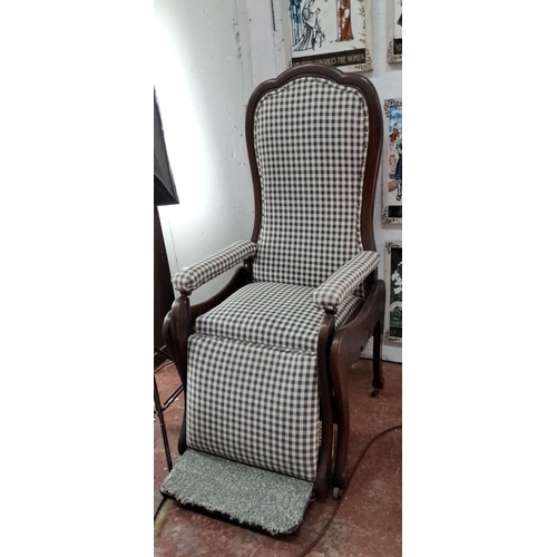 329 - Victorian-style reclining armchair with checkered upholstery and curved mahogany frame.