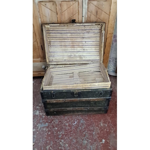 349 - Antique wooden steamer trunk with metal straps and leather handles. Interior lined with striped fabr... 