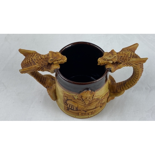 22 - Stoneware tankard with dragon-shaped handles and medieval knight relief, showcasing intricate detail... 