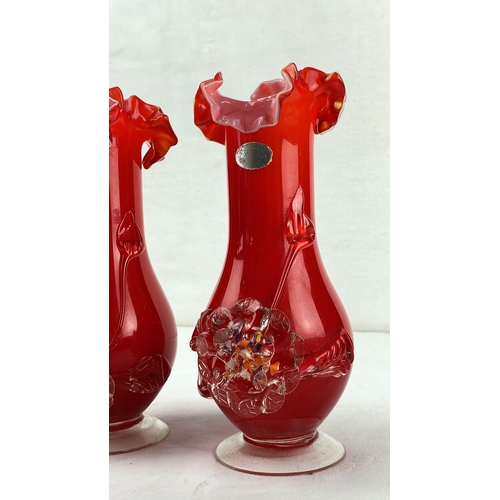 24 - Pair of ruffled red glass vases with applied floral decoration.