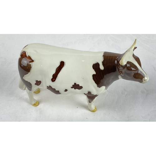 28 - Beswick porcelain cow figurine, hand-painted with brown and white glaze. Marked 