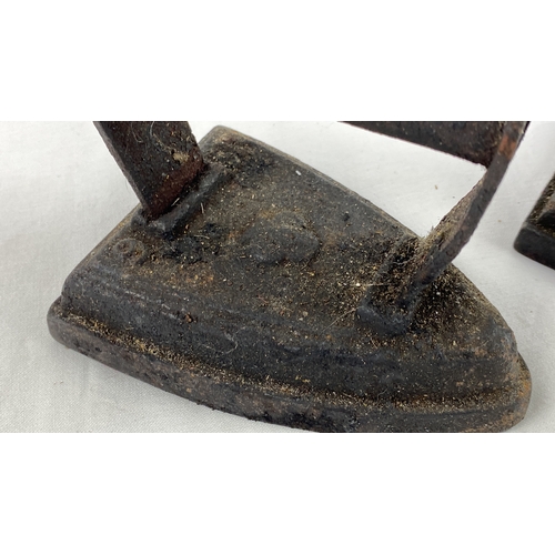 31 - Pair of vintage cast iron irons, featuring a smooth base and arched handle.