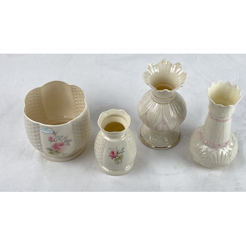 40 - Four porcelain vases featuring floral patterns and lattice designs. The vases are in creamy tones wi... 