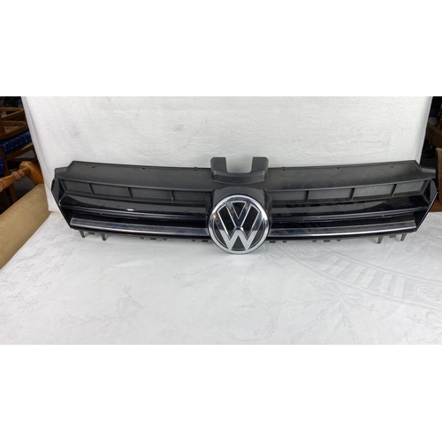 52 - Volkswagen front grille with emblem, black plastic with chrome detailing.