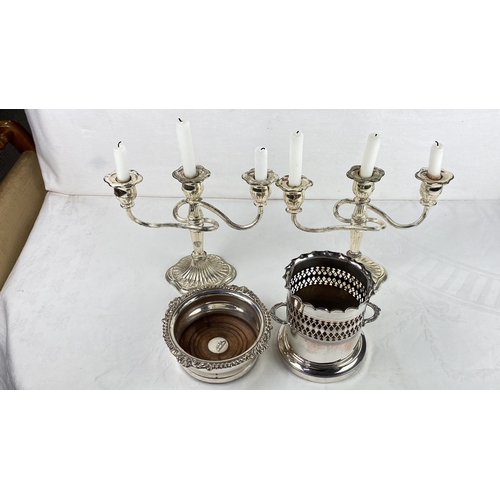 63 - Silver plated candelabra with two matching coasters and a wine bottle holder.