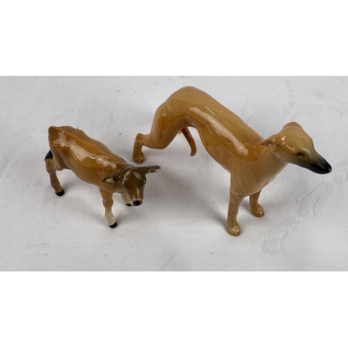 9 - Two Beswick ceramic animal figurines: a calf (a/f) and a greyhound, detailed in a smooth, light brow... 