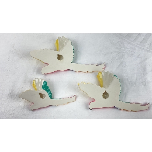 29 - Set of three ceramic flying parrot wall plaques.