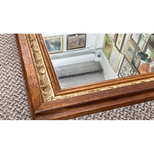 449 - Rectangular mirror with an ornate oak frame and a detailed floral inner border.  Measuring 69x59cm.