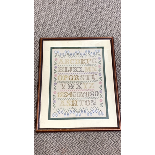 453 - Framed cross-stitch sampler with alphabet and numbers, featuring floral motifs, signed 