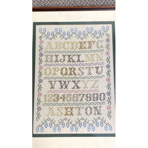 453 - Framed cross-stitch sampler with alphabet and numbers, featuring floral motifs, signed 