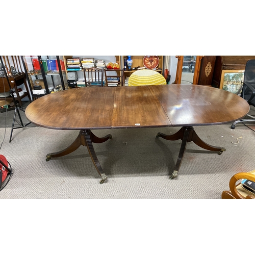 456 - Mahogany extending dining table with twin pedestal base and brass claw feet. Approximately 72 inches... 