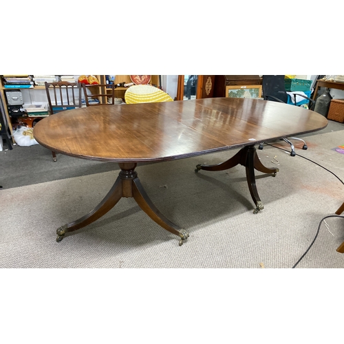 456 - Mahogany extending dining table with twin pedestal base and brass claw feet. Approximately 72 inches... 