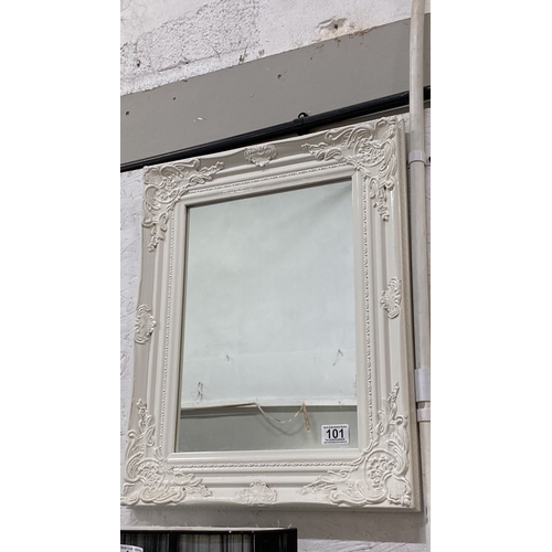 101 - White ornate framed mirror, featuring intricate decorative detailing in a classical style.