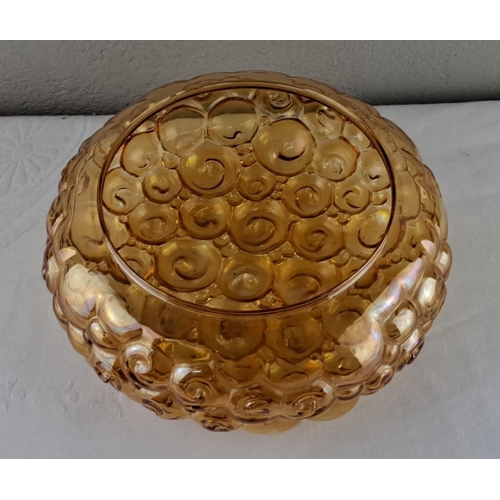 18 - Amber carnival glass lampshade featuring an embossed swirl design, 24cm diameter.