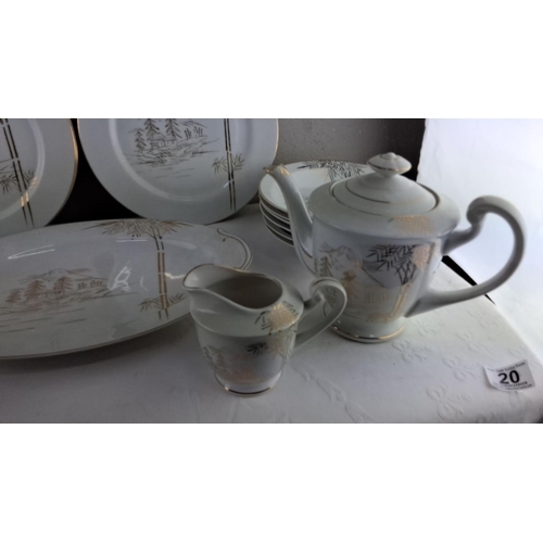 20 - Porcelain tea set comprising plates, teacups, saucers, teapot, sugar bowl, and creamer with pastoral... 