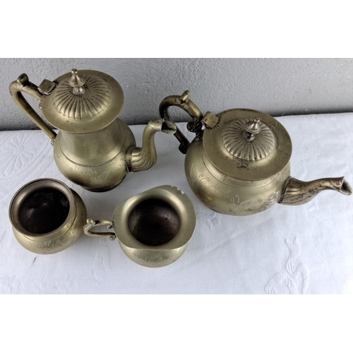 23 - Four-piece vintage brass set with floral engravings, including a teapot, coffee pot, sugar bowl, and... 