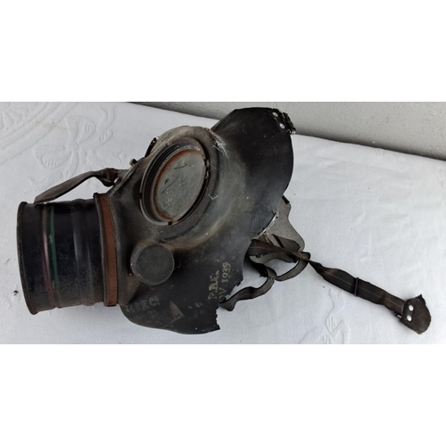 26 - World War II-era gas mask, featuring original rubber construction and canister. Embossed with 