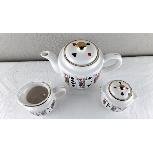 45 - Porcelain tea set with playing card motif and gold accents, including a teapot, sugar bowl, and crea... 