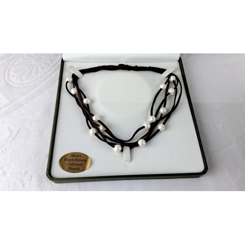 55 - Akoya hand-strung cultured pearl necklace with black cord, presented in box.