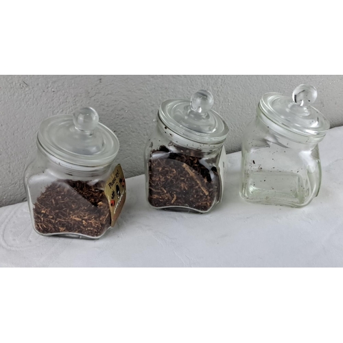 64 - Set of three vintage tobacco jars with glass lids, featuring 