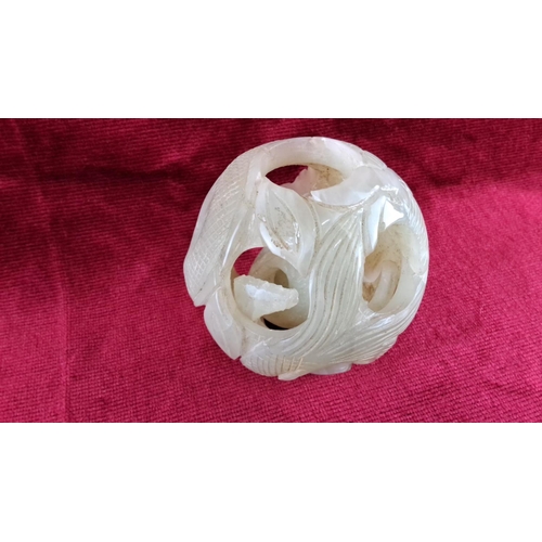 77 - Carved jade puzzle ball with dual layer design, featuring floral and geometric patterns (a/f).