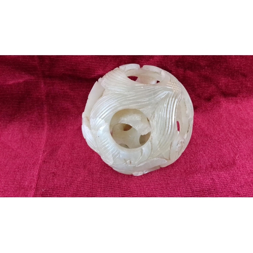 77 - Carved jade puzzle ball with dual layer design, featuring floral and geometric patterns (a/f).