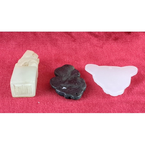 79 - Set of three carved jade pieces, featuring a lion, floral motif, and animal head.