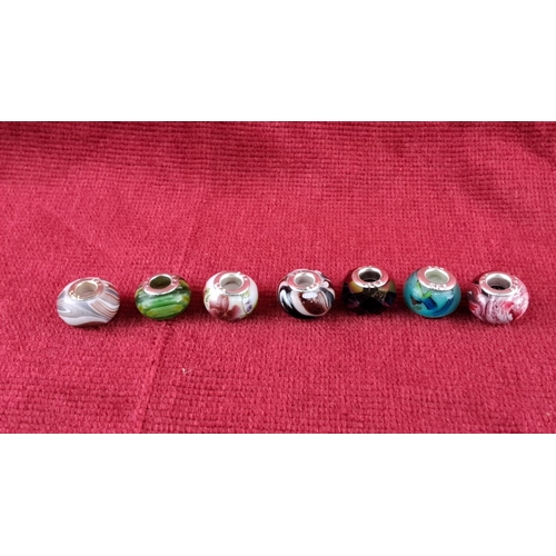 84 - Assorted bead collection featuring colorful glass charms with varied designs, including floral and h... 