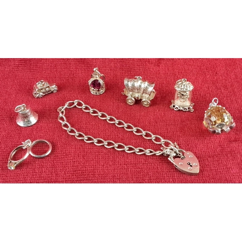 92 - Sterling silver charm bracelet with seven charms, including a heart lock, each intricately designed.... 