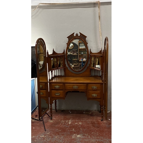 488 - Mahogany dressing table with oval mirror and ornate brass handles, featuring five drawers and side s... 