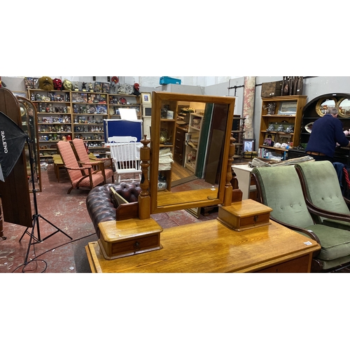 493 - Oak dressing table with three drawers and a swiveling mirror, featuring turned supports. Approximate... 