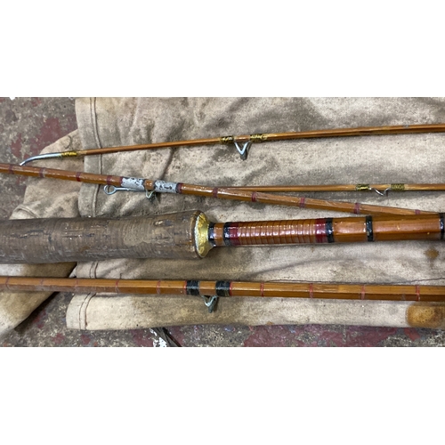 496 - Vintage cane fishing rods with original canvas holder, featuring cork handle and metal fittings. App... 