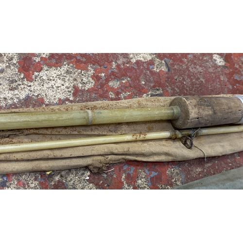 496 - Vintage cane fishing rods with original canvas holder, featuring cork handle and metal fittings. App... 