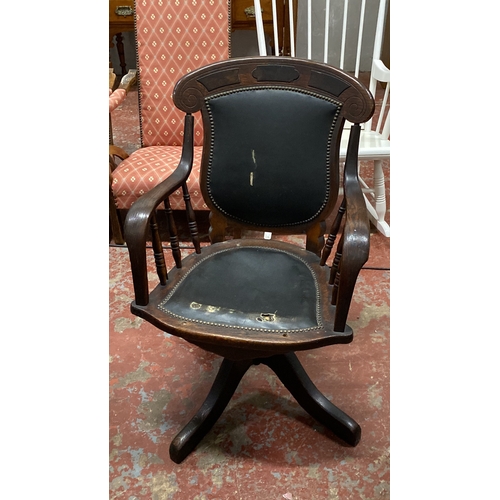 503 - Oak swivel desk chair in Victorian style, featuring turned arm supports and a leather backrest.