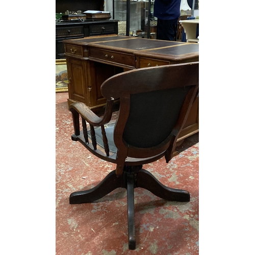 503 - Oak swivel desk chair in Victorian style, featuring turned arm supports and a leather backrest.