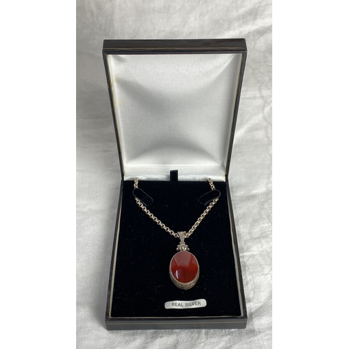 105 - Sterling Silver necklace with large fob featuring an oval red gemstone with hallmark 925, total weig... 