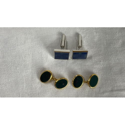 109 - Pair of cufflink sets featuring blue checkered enamel and gold-tone metal with green stone inset.