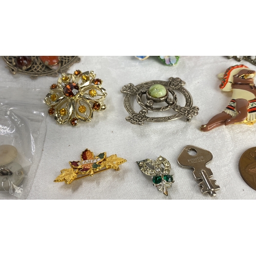 115 - Collection of vintage brooches and pins includes floral motifs, enamel detailing, and various gemsto... 