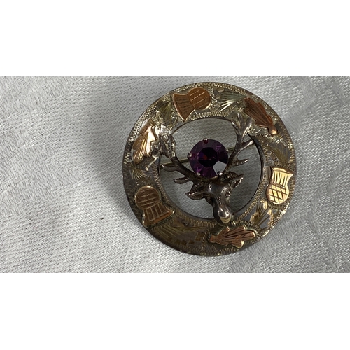 116 - Scottish silver brooch features a stag motif, with amethyst stone, copper and silver detailing.