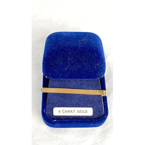 119 - 9 carat gold tie clip, featuring a grooved design, housed in a blue velvet case. Maker's mark inscri... 