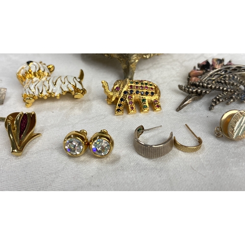 123 - Collection of vintage brooches and earrings featuring gold-tone metal and enamel accents. Includes h... 